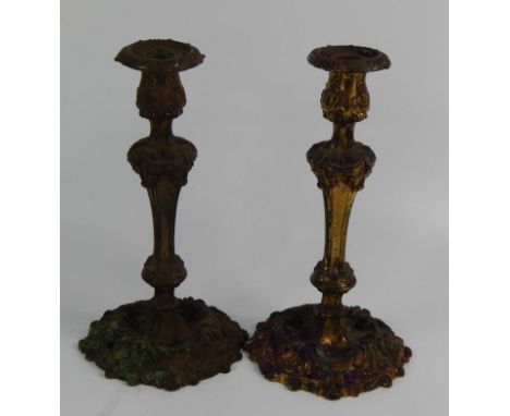 A pair of 19thC French gilt metal candlesticks, each cast with scrolls and shells in rococo style, 31cm high, (AF).