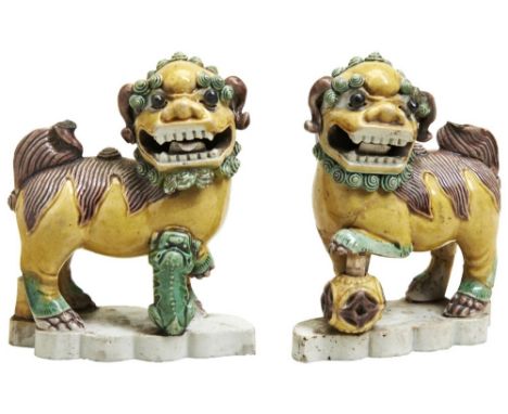 PAIR OF FAMILLE VERTE BISCUIT PORCELAIN MODELS OF BUDDHIST LIONS, DOGS OF FOE,  KANGXI PERIOD (1662-1722). the male with an o