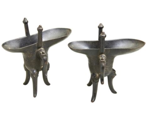 A PAIR OF BRONZE ARCHAISTIC RITUAL TRIPOD WINE VESSELS, JUE FOUR CHARACTER MARK ????, QING DYNASTY (1644-1911) with a curved 