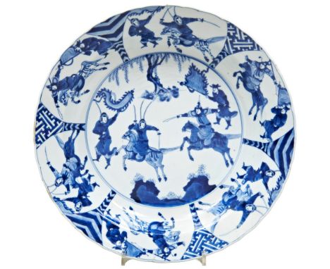 LARGE BLUE AND WHITE CHARGER KANGXI PERIOD (1662-1722) painted in tones of underglaze blue with equestrian soldiers warriors,