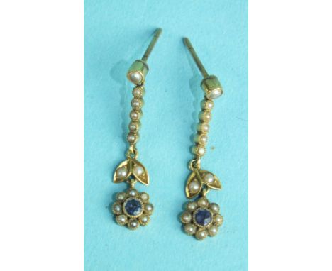 A pair of Edwardian drop earrings, each set a lilac stone and seed pearl flower-head cluster below six seed pearls and post f