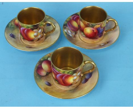 A pair of Royal Worcester porcelain coffee cans and saucers painted with fruit by Harry Ayrton, dated for 1935 and a similar 