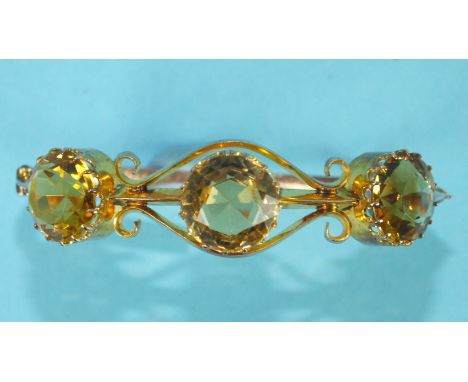 A late-Victorian 9ct rose gold hinged bangle claw-set three round-cut citrines, on knife-wire mount united by two scrolls, be