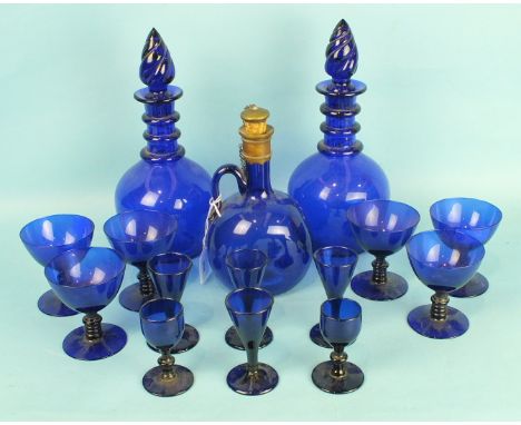 A deep blue glass flask with metal mount and stopper, 22cm high and a pair of blue glass decanters with spiral-twist stoppers