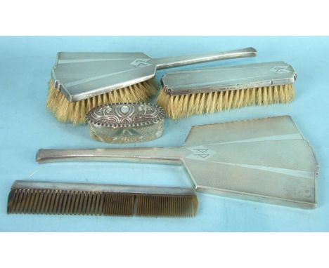 An Art Deco hand mirror, two brushes and comb, Birmingham 1934 and an oval-lidded cut-glass trinket box, (5).