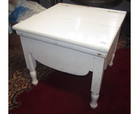 A Victorian white painted commode on turned feet.