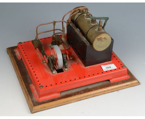 A Mamod style static steam engine with a brass tank leading to two pistons operating a wheel, drilled metal base.