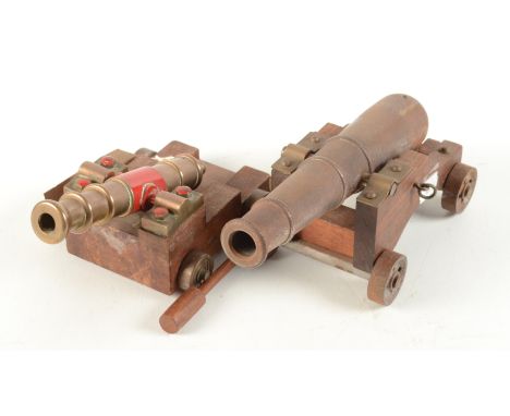 A bronze and part red painted model of a canon, barrel length 15cm, together with a steel model of a canon, barrel length 21c