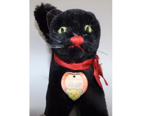 A Steiff black cat in frightened pose, paper label to neck, full height 12".