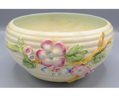 A Clarice Cliff bowl, the ribbed body decorated with a floral and leafy branch, diameter 20cm.