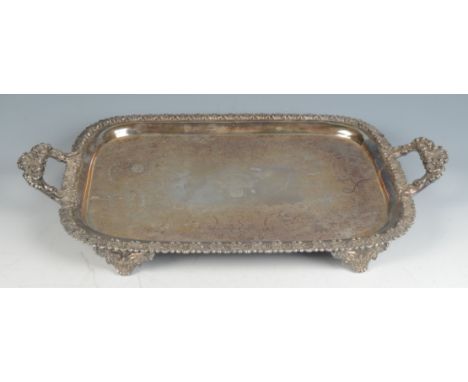 A rectangular tray engraved with flowers about an armorial shield, the rim and handles cast with shells, length including han