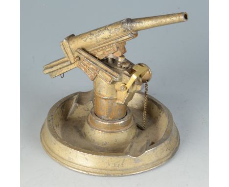 A die cast ashtray mounted with a model field gun hinged to reveal a table lighter.