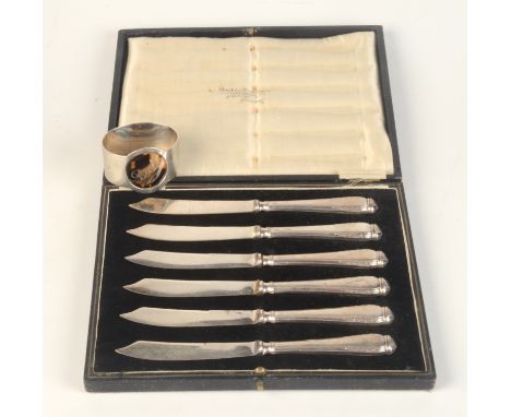 A set of six cake knives with filled silver handles together with a silver napkin ring with a tortoiseshell panel pique inscr