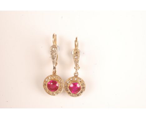 A pair of French gold earrings each with a ruby surrounded by diamonds.