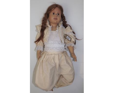 A modern ceramic doll marked China, length 28"