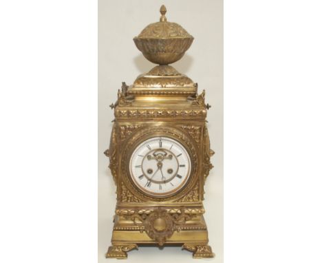 An impressive French brass mantle clock, 19th century, the large acanthus leaf decorated finial above a 12.3cm white enamel d