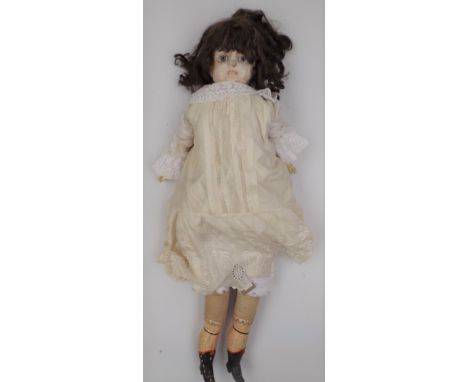 A late Victorian wax head doll, the head with inset paper weight eyes, the fabric body with ceramic forearms and legs, height