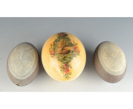 A pair of emu eggs, Australian, 19th century, the first decorated with an emu and her chick, height 13.5cm, the other with a 