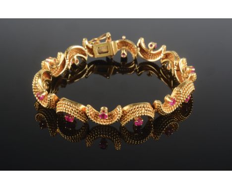 A Tiffany & Co 1950's 18ct gold bracelet each of the 14 cannetille crescents centred by a ruby, the clasp stamped Tiffany and