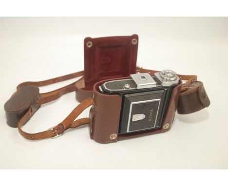 A Zeiss Icon Ikonta camera, in a brown leather case together with a Telex rangefinder and a lens hood.  