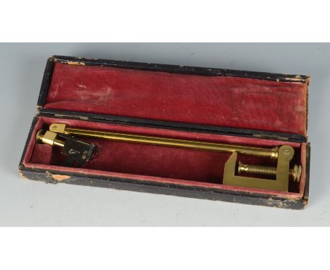 A cased brass instrument with a bench clamp on an adjustable arm, the head with two knurled wheel adjustments connected to a 