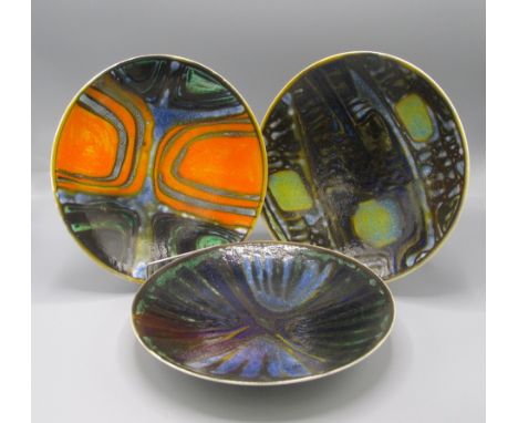 Three Poole Pottery lustre glazed dishes, each with polychrome abstract designs, diameters 26.7cm, 26.5cm and 27cm.   Conditi
