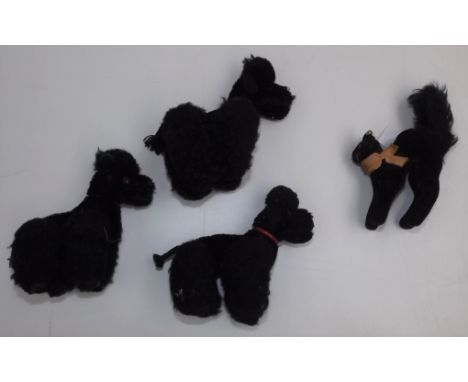 A miniature black cat in surprised pose by Steiff with button in left ear, full height 5", together with three miniature plus