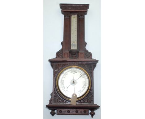A Victorian carved oak wall barometer, with a 19cm diameter dial, height 77cm, width 33cm.
