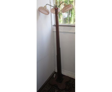 An Art Deco mahogany standard lamp with three pink glass circular shades on a square tapering column and shaped base, height 