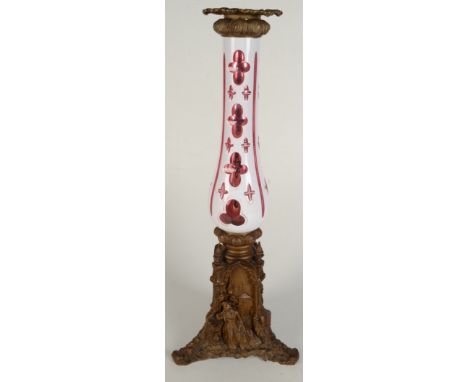 A gilt metal and glass lamp base, late 19th / early 20th century, with a Bohemian overlaid ruby and opaque glass body on a ba