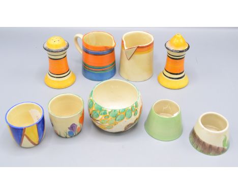 A pair of Clarice Cliff salt and pepper pots, height 8.5cm, two cream jugs and four egg cups.   Condition report:  Chips to h