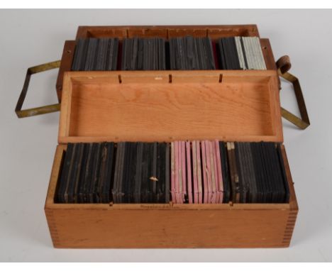 Two hardwood boxes containing a collection of coloured glass magic lantern slides including Alice in Wonderland, Boer War and