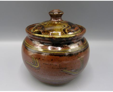 A Ray Finch Winchcombe Pottery jar and cover, the brown ground with abstract designs, height 11.5cm.  