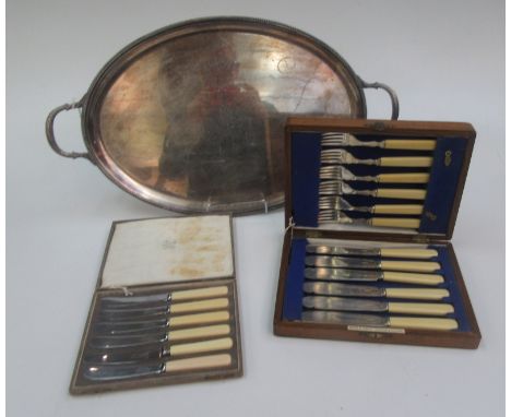An oval tray with a rope twist cast border, a set of fish knives and forks with Ivorene handles in an oak canteen and a cased