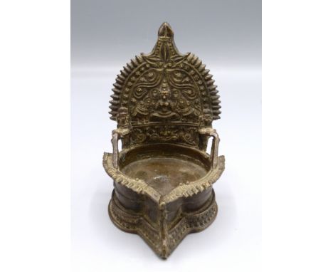 An Indian bronze wick lamp decorated with a seated goddess flanked by elephants, height 13.5cm. 