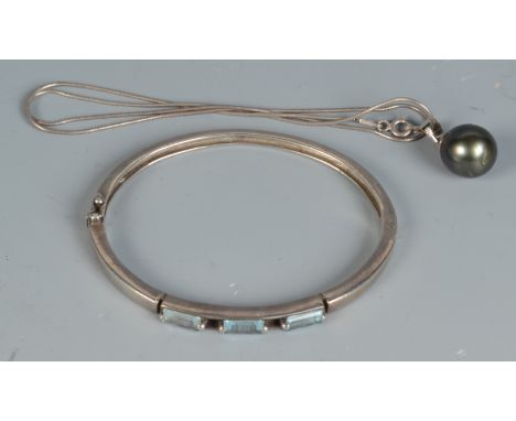 A silver and tourmaline bangle together with a 11mm black pearl pendant on silver snake chain. 