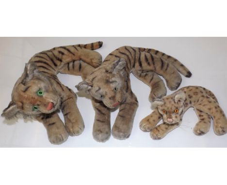 Three Steiff recumbent tigers, the larger with button in left ear, the largest 14" long.