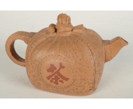 A Chinese Ixing stoneware teapot modelled as a seal wrapped in a cloth and tied in a bow to form the handle of the cover, the