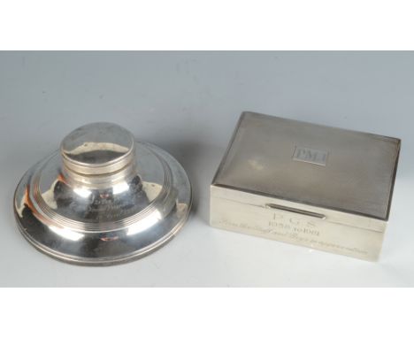 An engine turned silver cigarette box and a silver Capstan inkwell. 