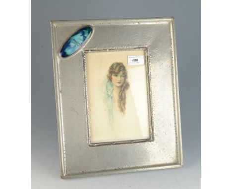 A pewter picture frame, early 20th century, set with a large oval cabochon, with a silk portrait of a girl in the style of Ki