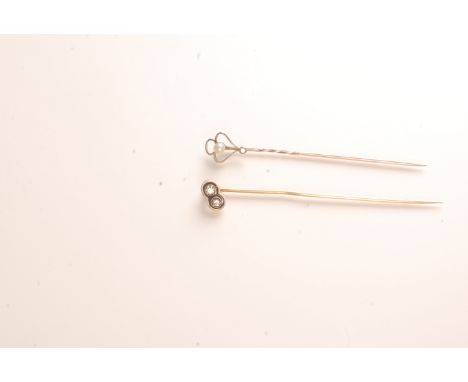 A gold and white enamel stick pin set two diamonds and one other stick pin.