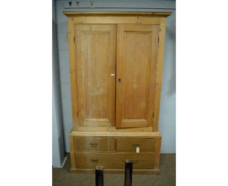 A Vintage pine wardrobe, with ogee cornice above a pair of panel door enclosing hanging space, two short and one long drawer 