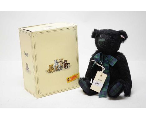 A Steiff limited edition musical teddy bear, with green nose and green tartan ribbon, button and label to ear, in box.