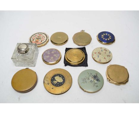 A collection of compacts by Stratton and others; and an inkwell.
