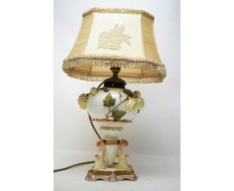 A ceramic table lamp, with moulded leaves and flower decoration in high relief, with shade, 49cms high overall.