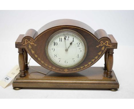 An Edwardian mahogany miniature mantel clock, with bow decoration, raised on twin pillar supports over a rectangular base, 16