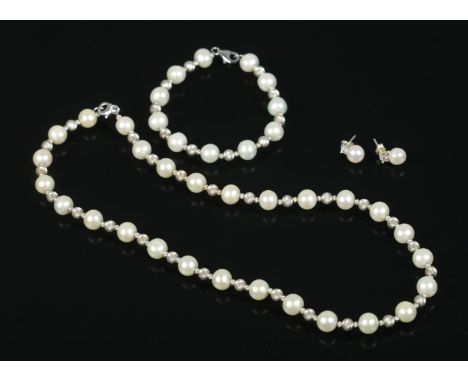 A silver and pearl three piece jewellery suite. Consisting of necklace, bracelet and earrings. Necklace unclasped: 44cm. Brac
