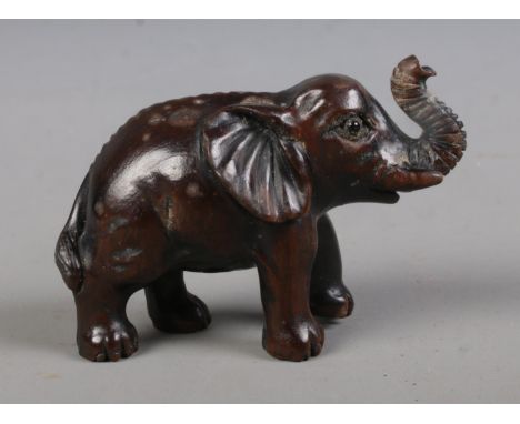 A Japanese carved hardwood Netsuke formed as an Elephant and bearing three character mark to underside.  
