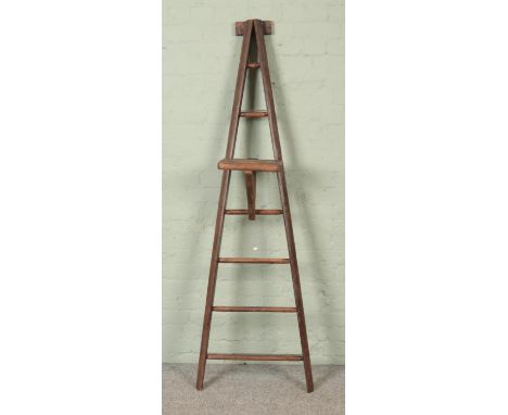 A seven rung wooden A-Frame ladder, possibly for fruit picking, with a platform step. Height: 191cm.  