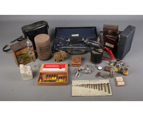 A large box of collectables. Includes vintage tins, cased binoculars, galileo thermometer, cased bakelite Megger Evershed &am